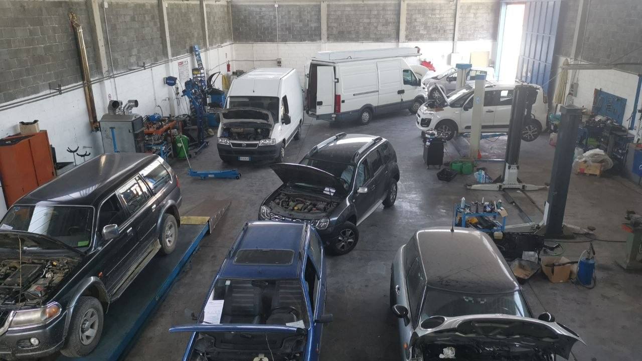 Interno dell'officina 3L Car Point con auto sui ponti